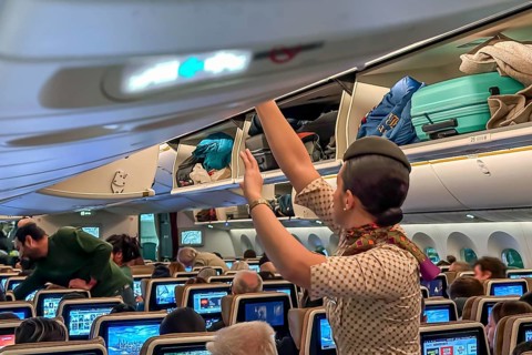 Etihad airline aircraft, interior, rows of seats with passengers. Boeing 787 aircraft on a flight