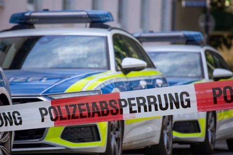 (Photomontage) Symbolic image of a police operation: police cordon in front of an emergency vehicle