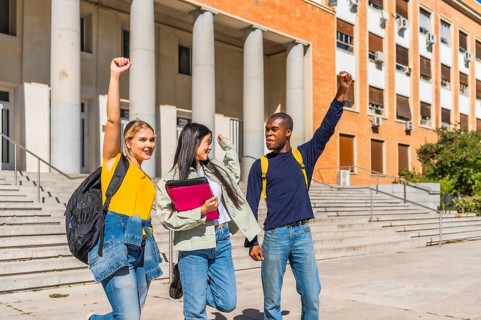 Multi-ethnic happy university students raising fist celebrating the finish the school day