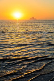 Ferry and sunset on the west coast of Norderney, Lower Saxony, Germany