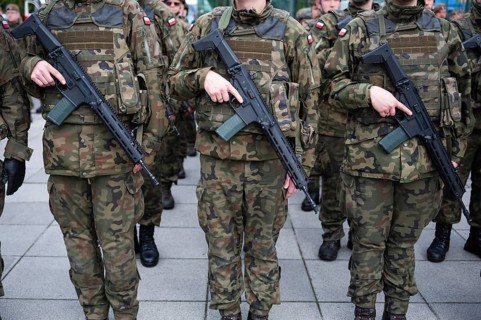 Polish army soldiers holding rifles on their bellies during roll call. Poland