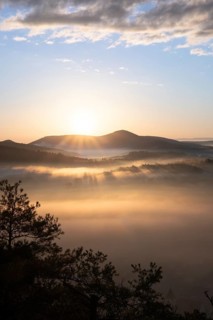 Mystical sunrise at the Wachtfelsen. Fascinating landscape shot between fog and clouds near