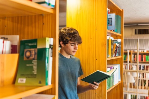 Teenager reading two bookcases