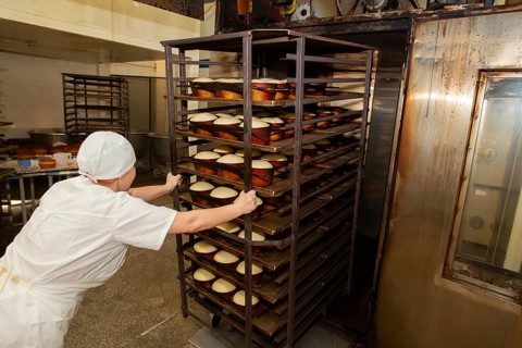 Belarus, the city of Gomil, April 25, 2019. Bakery.A bakery worker places trays with raw bread in