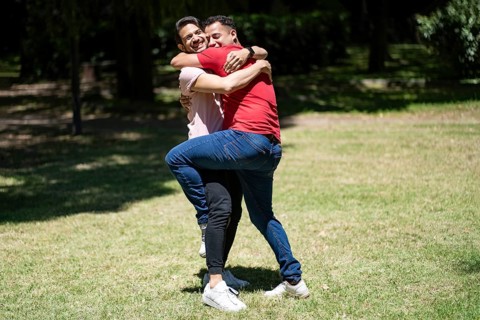 Couple of latin men hugging in a park