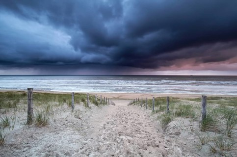 Stormy sky and showers over North sea beach, Netherlands