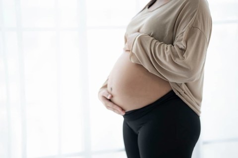 Pregnant woman holds hands on belly touching her baby caring about her health Beautiful happy