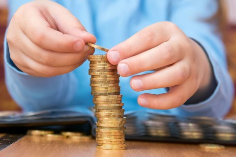 Child amassed a large pile of gold coins, close-up