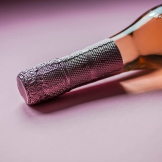 Bottle of rose champagne wine in minimal composition on pink background with copy space. Natural
