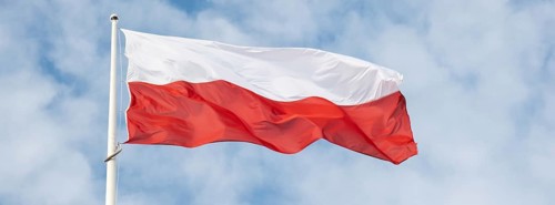 Flag of Poland waving at wind against beautiful blue sky. Polish flag White and red flutters on