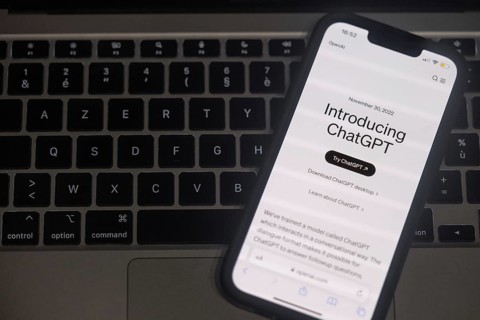 OpenAI software ChatGPT application on a mobile phone above a computer keyboard