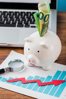 High angle office items with piggy bank growth chart
