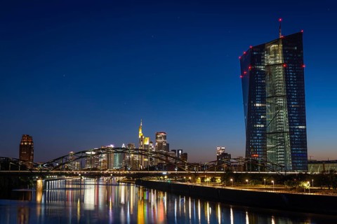 The European Central Bank (ECB) and the Frankfurt banking skyline are reflected in the calm waters