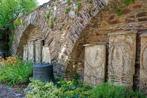 Remains of the town wall behind St Nicholas' Church with the gravestones of former priests of the