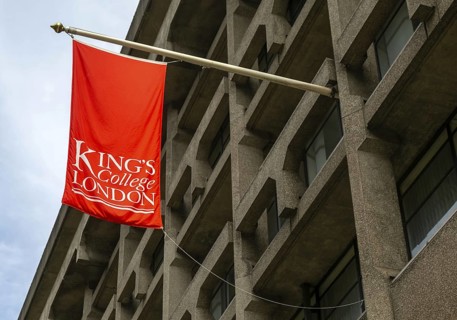 Red flag banner hanging from building Strand Campus, King's College university, London, England, UK
