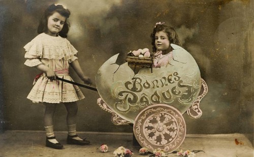 Child sitting in large egg, 1930s, Two girls in a vintage Easter photo with flowers and decoration,