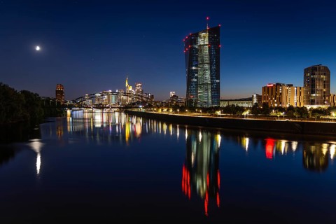 The European Central Bank (ECB) and the Frankfurt banking skyline are reflected in the calm waters