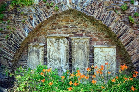 Remains of the town wall behind St Nicholas' Church with the gravestones of former priests of the