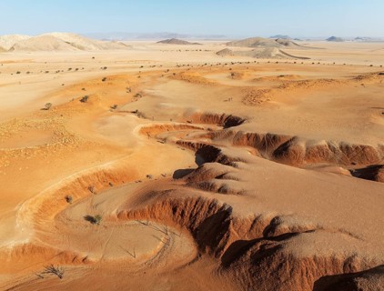 Canyons, arid plains grown with camelthorn trees (Vachellia erioloba) and isolated mountain ridges