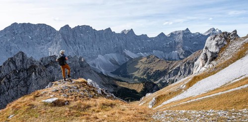 Mountaineers in front of a picturesque mountain landscape in autumn, view of the rocky ridge of the