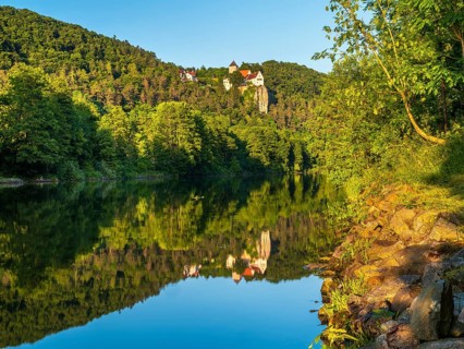Prunn Castle on a steep cliff above the Altmühl Valley in the evening light, reflection in the