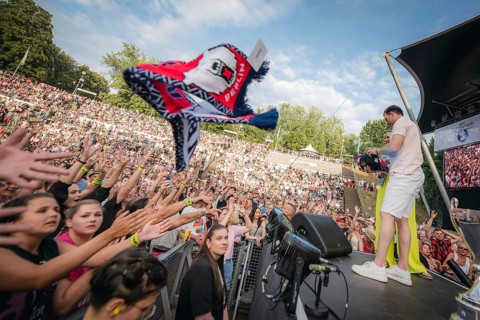 Eisbären Berlin players throw scarves and other fan merchandise into the audience at the Berliner