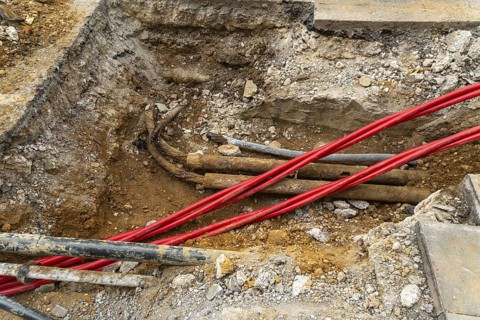 Underground cables and pipes under road surface, London, England, UK