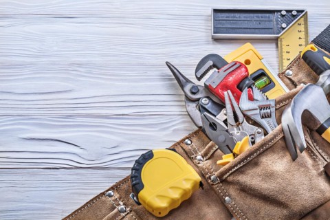 Construction of tools in a tool belt on a wooden board Construction concept