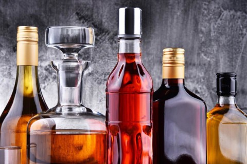 Composition with carafe and bottles of assorted alcoholic beverages