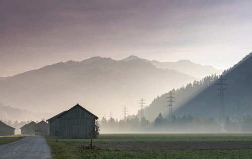 View of the Praettigau Valley near Klosters in Switzerland on an early morning with farm fields and
