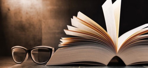 Composition with open book and glasses on the table