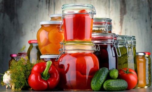 Jars with pickled vegetables and fruity compotes. Preserved food