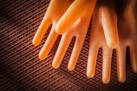 A pair of insulating gloves on a dielectric rubber mat