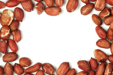 Raw shelled peanuts.Isolated border on white