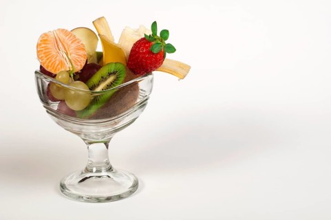 Fruit salad in a glass bowl on white background