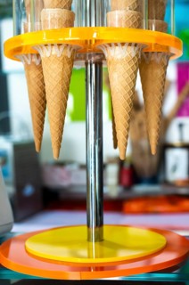Waffle cones for ice cream put on stand. Ice cream shop. Bright colours. Sweet food