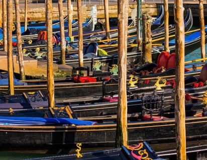 Magical journey to Venice. Gorgeous varnished gondolas offer a getaway on the Grande Canal. Bright