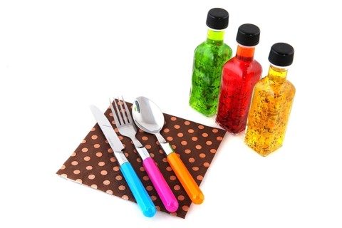 Colorful dressing with herbs in glass bottles