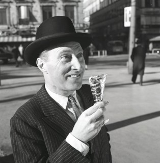 Ice cream in the 1960s. A well dressed gentleman in a suit and hat enjoys a ice cream on a sunny