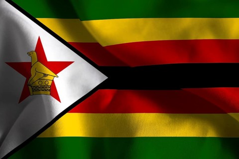 The flag of Zimbabwe features green, yellow, red, black stripes and a white triangle with a red