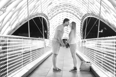 Young loving couple kissing on the bridge of Peace in Tbilisi, Georgia