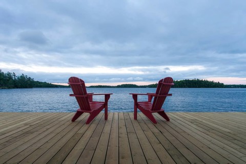 Known as Muskoka or Adirondack chairs sit on a dock at a resort in Muskoka, Ontario, Canada, North