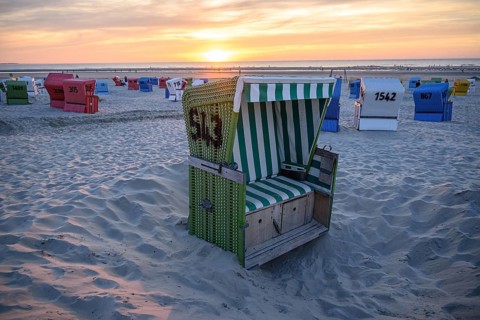 Single green beach chair on the beach at sunset with sea view, langeoog, east frisia, germany