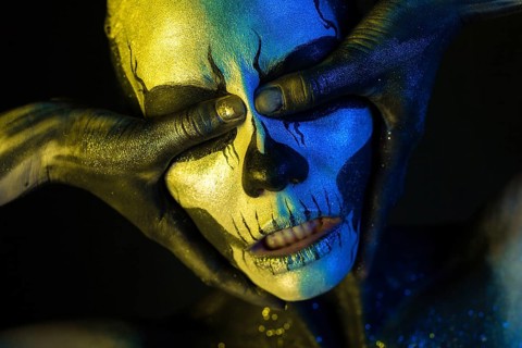 Isolated on black, closeup picture, toned yellow and blue, spooky young blonde caucasian pretty