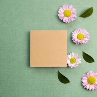 Blank memo pad with pink small flowered chrysanthemum on green background. flat lay, top view, copy
