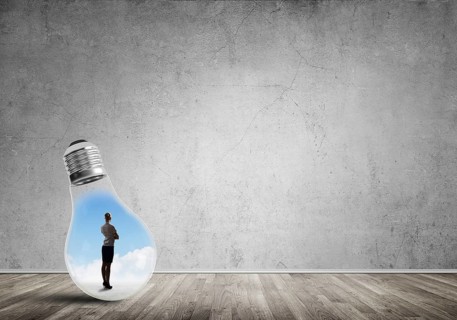 Businesswoman inside of light bulb in empty concrete room