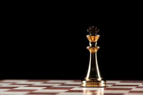 Golden king chess figure standing on chessboard. Intellectual and tactic game. Strategy planning,