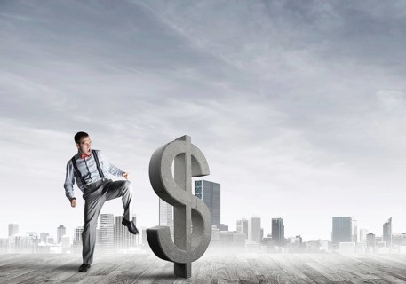 Determined banker man against modern cityscape breaking dollar cement figure