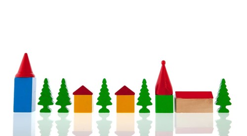 Small village in colorful wooden blocks with church and trees isolated over white background