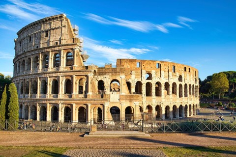View on the Collosseum from the Forum Romanum on a sunny day and with visitors in the Collosseum